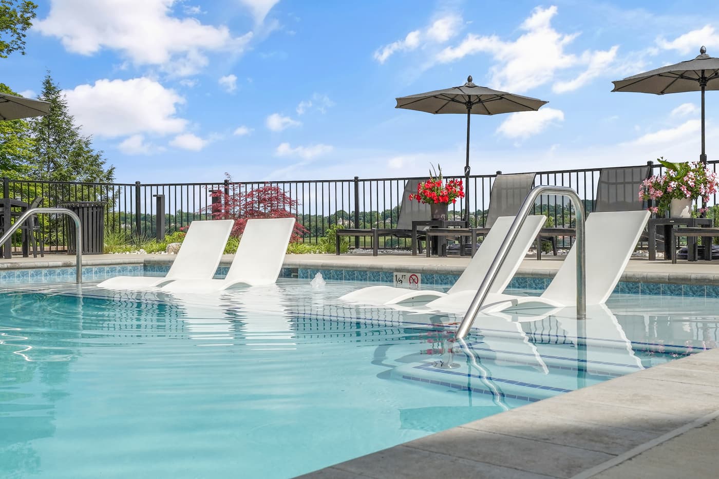 Community pool with lounge chairs and umbrellas