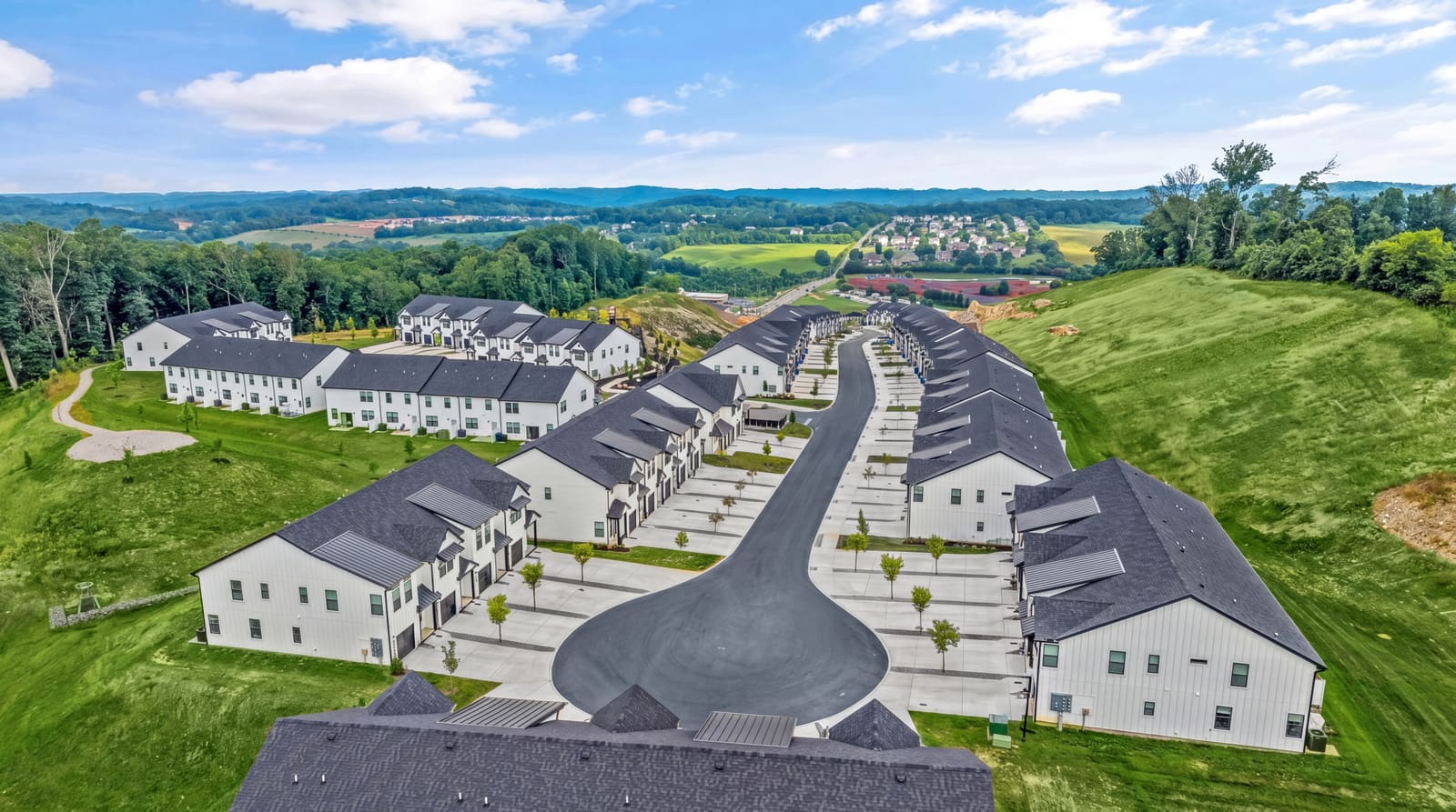 Aerial drone photo of a townhome community on rolling terrain