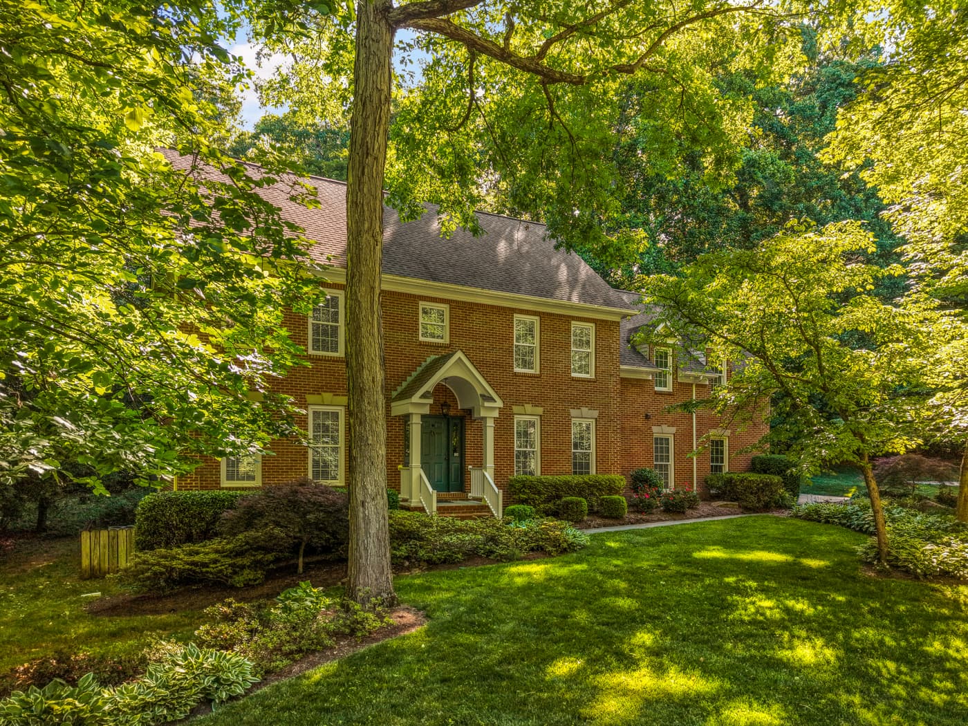 Brick colonial exterior framed by mature trees