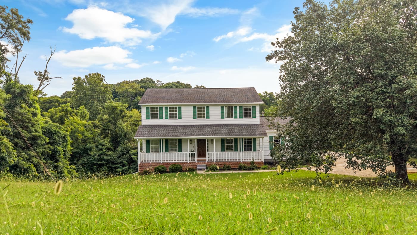 Exterior photo of a two-story colonial home on a wide green lawn