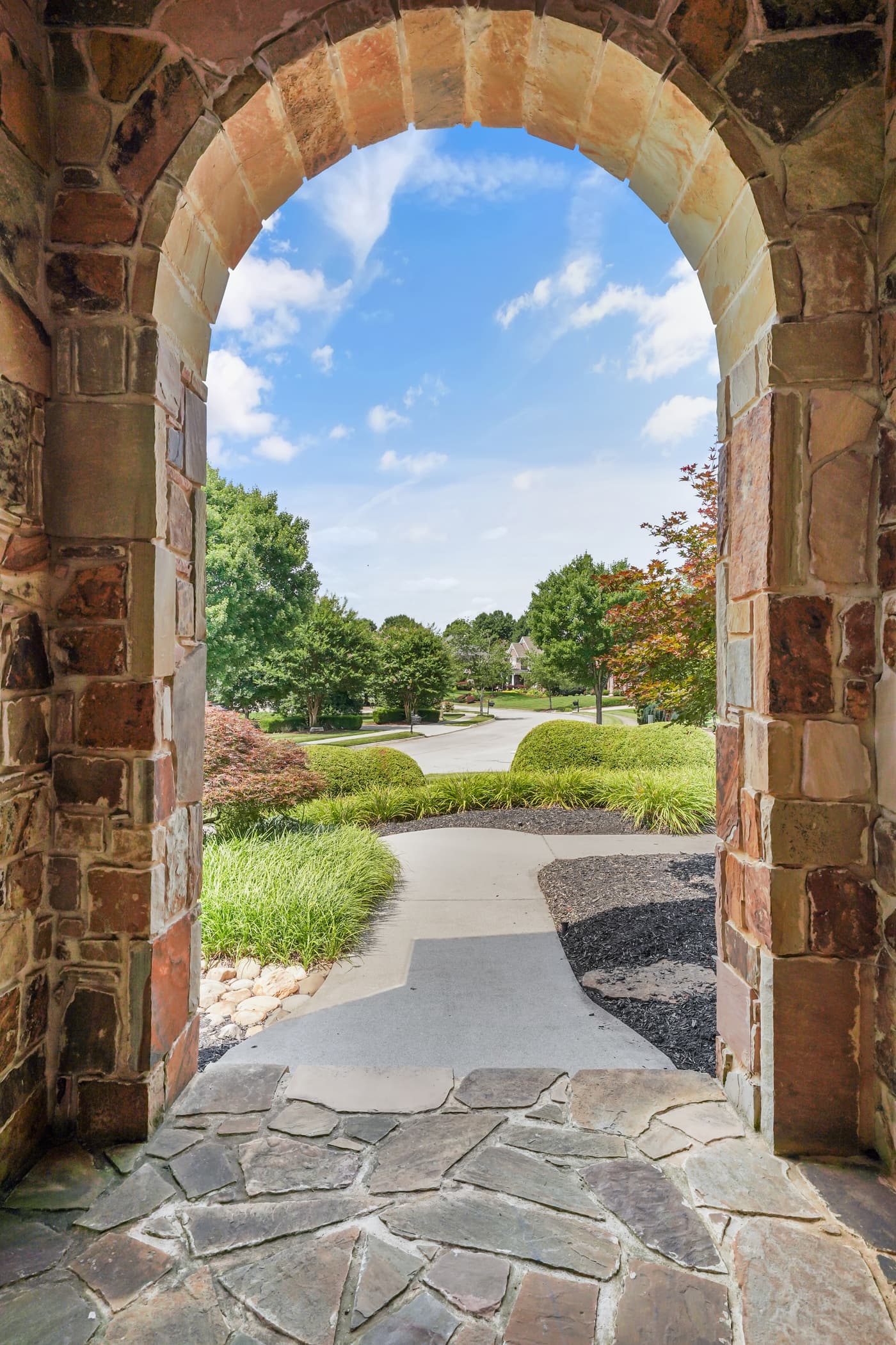 View from a stone front porch toward the neighborhood street